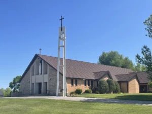 A modern brick church sanctuary with wooden accents and a cross.